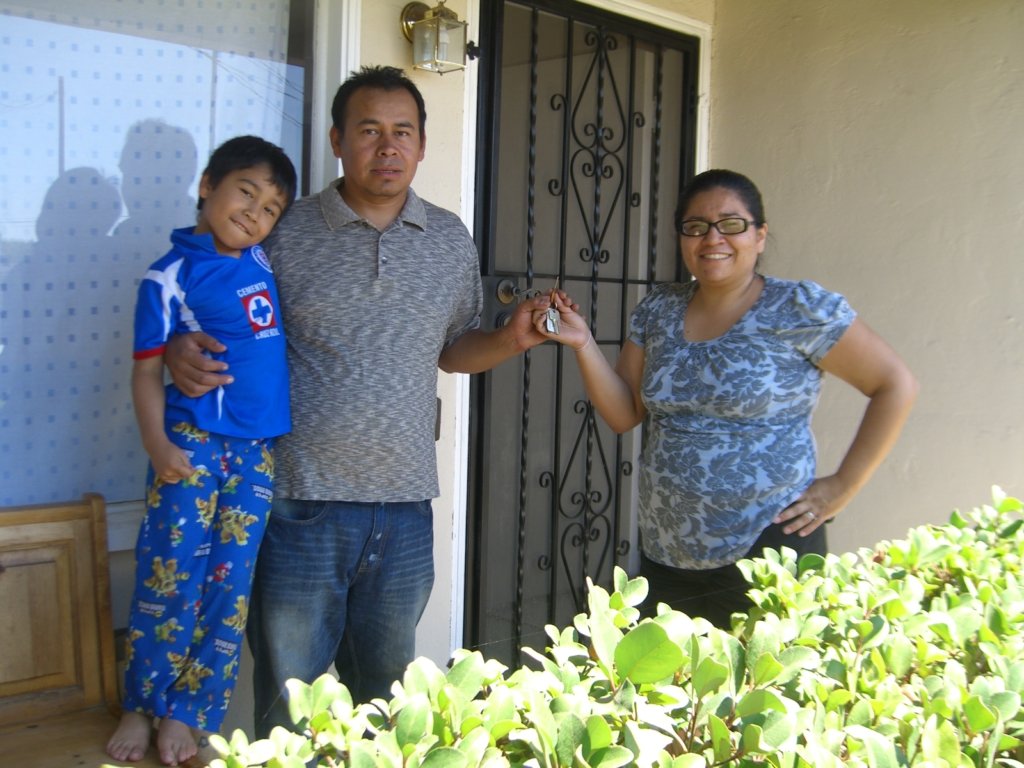 A family holds the keys outside their home.