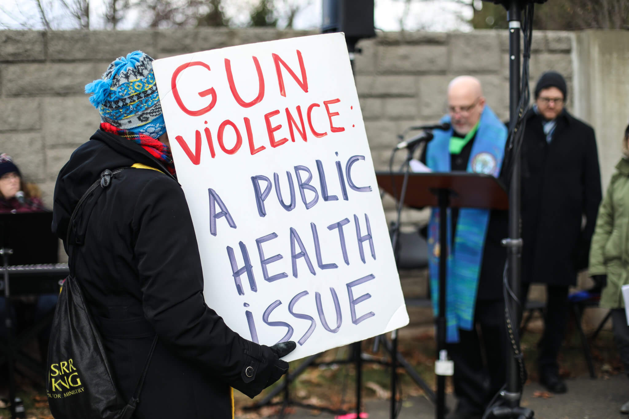 Sign is held up at a rally for gun safety measures.