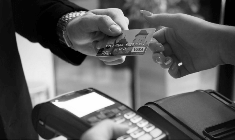 A black and white photograph of a close up of hands exchanging a credit card.