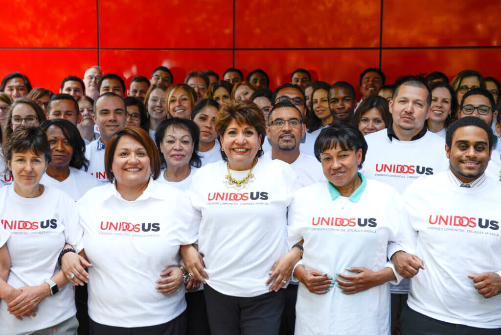 UUS Staff wearing UnidosUS shirt, arms linked.