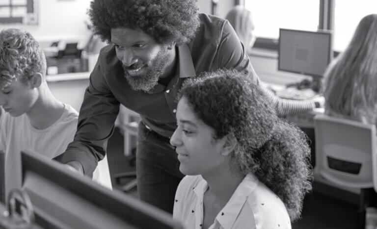 Teacher showing a student something on the computer.