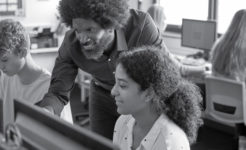 Teacher showing a student something on the computer.