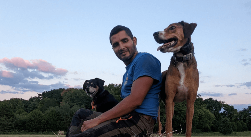 Johnny Ivanovich Nunez sitting with 2 dogs